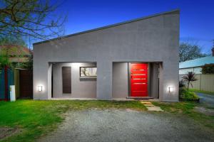 una puerta roja al lado de una casa en About Time Retreats- Studio Seven, en Mansfield