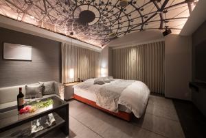 um quarto com uma cama e um tecto em caixote em HOTEL FINE - INTO THE PREMlUM - em Okazaki