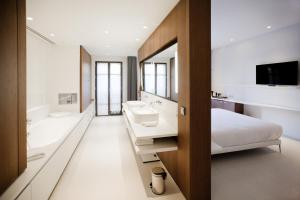 a bedroom with a bed and a tub and a sink at Hotel C2 in Marseille
