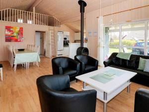 sala de estar con sofá, sillas y mesa en Four-Bedroom Holiday home in Storvorde en Egense