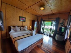 a bedroom with a bed and a television in it at Koh Chang Bailan Beach Resort in Ko Chang