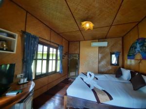 a bedroom with a bed and a tv in it at Koh Chang Bailan Beach Resort in Ko Chang