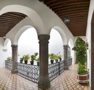 una galleria con piante in vaso su un balcone di Hotel Senorial a Querétaro