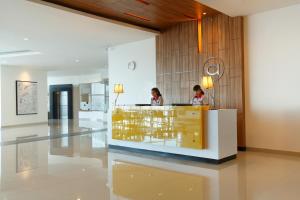two people sitting at a counter in a lobby at Amaris Hotel Season City in Jakarta