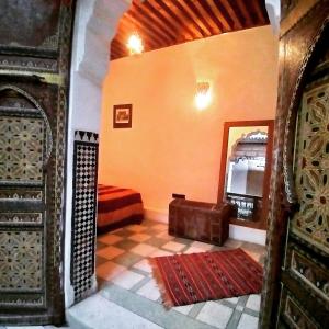 een kamer met een slaapkamer met een spiegel en een bank bij Dar Rbab in Fès