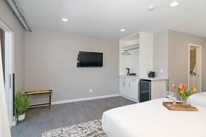 a white room with a bed and a kitchen at Sands Of La Jolla in San Diego