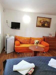 a living room with an orange couch and a table at Ubytovanie na súkromí KIKA in Santovka