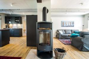 a living room with a wood stove in the middle at Reethus Glücklicher Matthias Hausteil Waasterlun in Oldsum