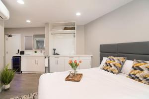 una camera da letto con un letto bianco e un vaso di fiori di Sands Of La Jolla a San Diego