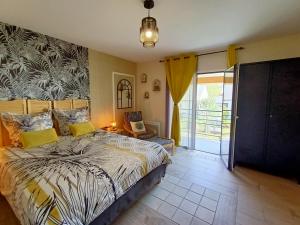 a bedroom with a bed and a chair in it at Le balcon des cimes in Adast