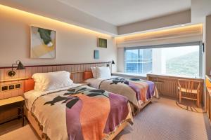 a hotel room with two beds and a window at the Arca in Hong Kong