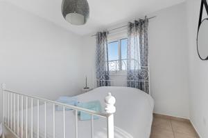 a white crib in a white room with a window at Glabur Stays - The Sunny Atelier - Nicosia City, Free Parking & Wifi, Welcomes You!!! in Nicosia