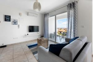 a living room with a couch and a tv at Glabur Stays - The Sunny Atelier - Nicosia City, Free Parking & Wifi, Welcomes You!!! in Nicosia
