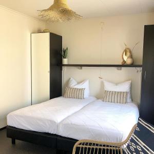 
a bedroom with a bed and a dresser at Hotel Panta Rhei Cadzand-Bad in Cadzand
