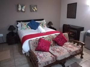 a bedroom with a bed and a couch at Harties Double Bed 2 Sleeper Room with Shower in Hartbeespoort