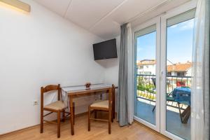a room with a desk and a window with a balcony at Apartments Orbanić in Rovinj