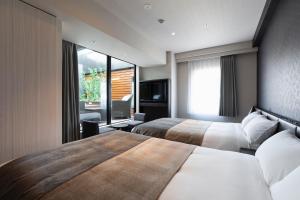 Una habitación de hotel con dos camas y una ventana. en HOTEL ASYL TOKYO KAMATA, en Tokio 33 fotos más