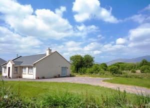 a small white house with a gravel driveway at Shannons Gate in Killorglin