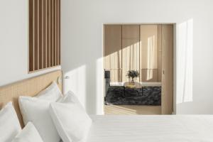 a bedroom with a white bed and a room with a table at Original Sokos Hotel Tripla Helsinki in Helsinki