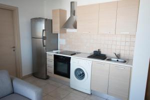 a kitchen with a washing machine and a refrigerator at Glabur Stays - The Sunny Atelier - Nicosia City, Free Parking & Wifi, Welcomes You!!! in Nicosia