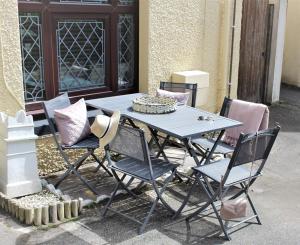einem blauen Tisch und Stühlen außerhalb eines Gebäudes in der Unterkunft Gorgeous cottage by sandy beach Dog friendly in Port Erin