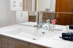 a bathroom with a white sink and a mirror at Gairoju / Vacation STAY 2366 in Higashi-osaka