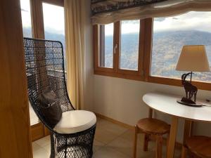 a room with a chair and a table with a window at Eanta SUNNY & MOUNTAIN chalet 10 pers by Alpvision Résidences in Veysonnaz