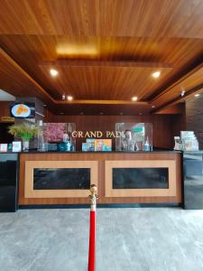 Grand Padis Hotel في Bondowoso: شريط احمر امام مطعم مع كونتر
