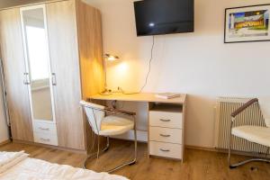 a bedroom with a desk with a chair and a bed at Ferienwohnung Sonnenseite in Freest