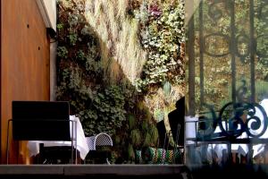 a wall covered in ivy with a chair and flowers at Hotel C2 in Marseille