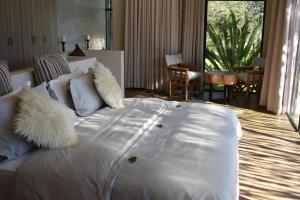 a large white bed with white pillows in a room at Sensiri Plains Safari Lodge in Mkuze