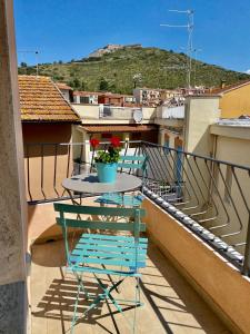 een tafel en stoelen op het balkon van een gebouw bij Loraia Design Rooms in Porto Ercole