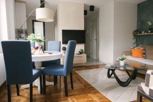salon ze stołem i niebieskimi krzesłami w obiekcie Apartman Marina Subotica w mieście Subotica