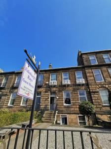 ein Schild vor einem Backsteingebäude in der Unterkunft Edinburgh Rays Guest House in Edinburgh