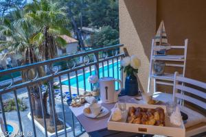 una mesa con una bandeja de comida en el balcón en Sanary sur mer, Soleil et douceur III, en Sanary-sur-Mer