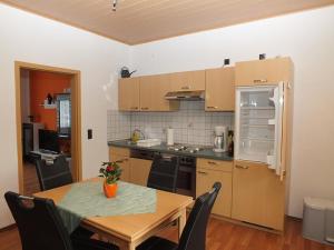 a kitchen with a table and a kitchen with a refrigerator at Ferienwohnung Klaus im Tal der Steinach in Steinach