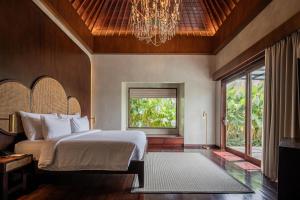 a bedroom with a bed and a window at The Garcia Ubud Hotel & Resort in Ubud