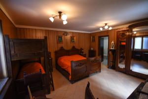 una camera da letto con pareti in legno e un letto con lenzuola arancioni di IL NIDO DEL FALCO a Pradleve