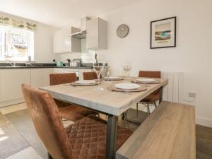 a kitchen with a dining room table with chairs at Trevena in Tintagel