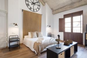 マラガにあるSantiago Premium Loft IIIのベッドルーム1室(ベッド1台、壁に大きな時計付)