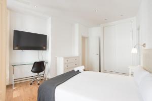 A television and/or entertainment centre at Urbe10 Plaza de la Constitucion 1 Bedroom Apartment