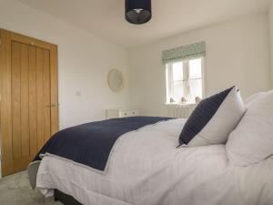 a bedroom with a large bed with pillows and a window at Trevena in Tintagel