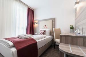 ein Hotelzimmer mit einem Bett und einem Schreibtisch in der Unterkunft Abasto Hotel München Feldmoching in München