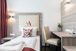 ein Hotelzimmer mit einem Bett, einem Schreibtisch und einem Stuhl in der Unterkunft Abasto Hotel München Feldmoching in München