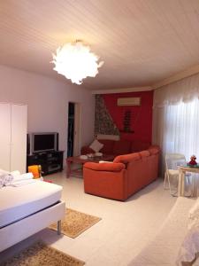 Una sala de estar con un sofá rojo y un televisor. en Roulas Cozy Apartments, en Artemida