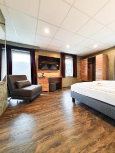 1 dormitorio con cama, sofá y TV en Winzerhaus Gärtner - An der Loreley en Sankt Goar