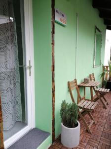 a porch with a chair and a potted plant at Apartma Metija LUX z savno in Kobarid