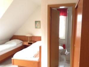 a bedroom with two beds and a bathroom at Pension An der Bleiche in Wustrau