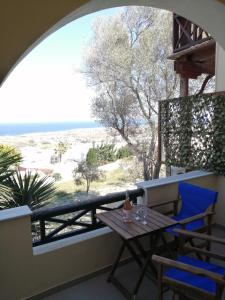 a table and chairs on a balcony with a view of the beach at Santo Spiti sou 3 in Fira