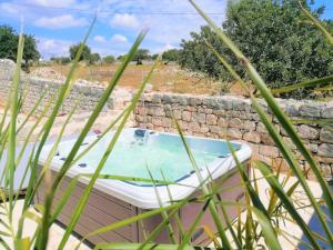 uma banheira de hidromassagem numa parede de pedra em Il Baglio di Kharrub rural guest house em Pozzallo